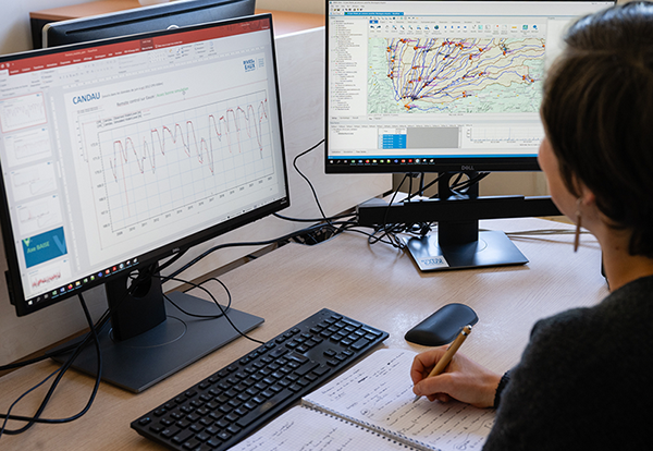 Sur cette image, on voit un ingénieur qui travaille devant son ordinateur pour réaliser une étude de gestion intégrée de la ressource en eau (GIRE) - Bureau d'étude hydraulique Rives & Eaux du Sud-Ouest