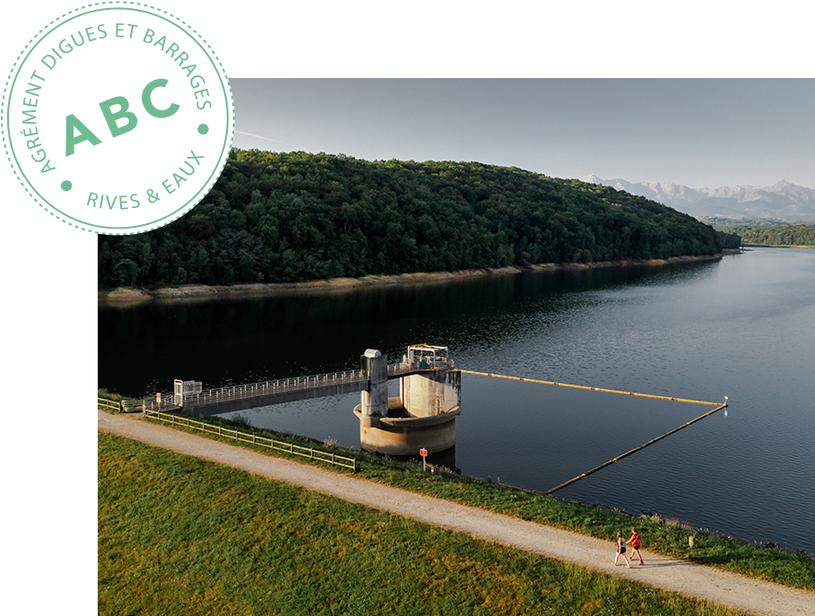 Cette photo nous montre un grand ouvrage hydraulique. Au-dessus, on peut lire le tampon suivant : Agrément digues et barrages classes A, B ou C – Bureau d'étude hydraulique Rives & Eaux du Sud-Ouest